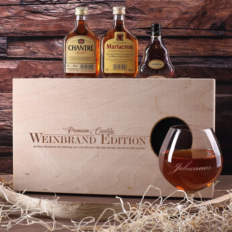 Cognac-Kollektion aus verschiedenen Weinbränden mit Weinbrandglas in gravierter Holzkiste