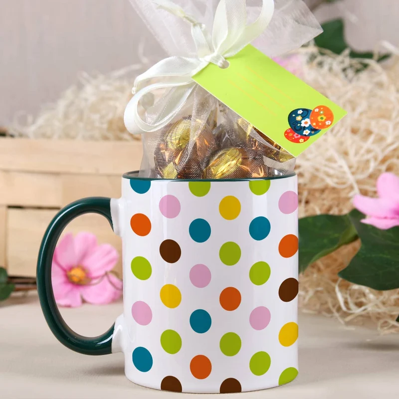 Tasse mit bunten Punkten und Schokoladenkugeln